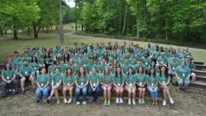 106 college student summer missionaries pose for picture in matching green shirts